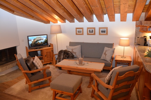 Bright living room vacation rental Engadin with balcony access